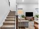 Cozy living room featuring a staircase, comfortable sofa, and entertainment center at 1206 Civitas Way, Winter Garden, FL 34787