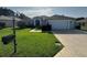 Charming single-story home with a well-manicured lawn, long driveway, and two-car garage at 13655 Se 97Th Terrace Rd, Summerfield, FL 34491