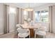Bright dining room with natural light, neutral tones, modern lighting, and seating for six around an octagonal table at 1389 Zesty Citrus Ln, Minneola, FL 34715