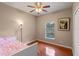 Bedroom with hardwood floors, a white bed with pink bedding, and a lamp at 1407 S Palmetto Ave, Sanford, FL 32771