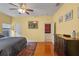 Main bedroom with hardwood floors, a ceiling fan, a dresser, and an ensuite bath at 1407 S Palmetto Ave, Sanford, FL 32771