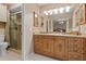 Well-lit bathroom featuring granite countertop vanity, framed mirrors, and convenient access to a glass-enclosed shower at 154 Golf Club Dr # 154, Longwood, FL 32779