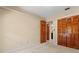 Bedroom featuring tan walls, carpet floors, and a closet with wooden doors at 154 Golf Club Dr # 154, Longwood, FL 32779