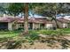 Inviting home exterior with a well-manicured lawn, mature trees, and updated landscaping at 154 Golf Club Dr # 154, Longwood, FL 32779