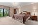 Large main bedroom features a plush carpet, decorative chandelier, and an expansive view of the lush backyard at 154 Golf Club Dr # 154, Longwood, FL 32779