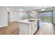 Open living room with an island, stainless steel appliances, and sliding glass doors to the patio at 16164 Point Rock Dr, Winter Garden, FL 34787