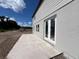 Exterior view showcasing the modern patio and white siding of the charming new home at 1646 Cane Bamboo Drive, St Cloud, FL 34771