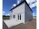 Exterior view showcasing the modern patio and white siding of the charming new home at 1646 Cane Bamboo Drive, St Cloud, FL 34771