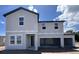 New two-story home with a modern design and a large, covered parking area for multiple cars at 1646 Cane Bamboo Drive, St Cloud, FL 34771