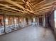 Open-concept home under construction featuring exposed wooden framework, high ceilings, and natural light from surrounding windows at 1646 Cane Bamboo Drive, St Cloud, FL 34771