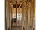 A view inside an unfinished home, showcasing the exposed stud framing and concrete slab, ready for customization at 1646 Cane Bamboo Drive, St Cloud, FL 34771