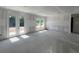View of an unfinished living room with glass doors and windows, providing access to the outdoors at 1646 Cane Bamboo Drive, St Cloud, FL 34771