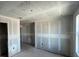 Unfinished living room featuring rough ceiling, drywall, and a doorway at 1646 Cane Bamboo Drive, St Cloud, FL 34771