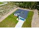 Aerial view of a single-Gathering home featuring a well-manicured lawn and a dark gray roof at 17301 Sw 41St Cir, Ocala, FL 34473