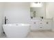 Bathroom featuring modern soaking tub, quartz vanity, and black fixtures at 17301 Sw 41St Cir, Ocala, FL 34473