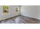 Bedroom with wood-look floors and two windows providing natural light and a view of greenery at 17301 Sw 41St Cir, Ocala, FL 34473