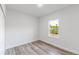 Cozy bedroom with neutral tones, wood-look floors, and a bright window at 17301 Sw 41St Cir, Ocala, FL 34473