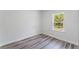 Bright bedroom features wood-look flooring and a window with a view of lush greenery at 17301 Sw 41St Cir, Ocala, FL 34473