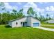 Charming single-Gathering home featuring a modern design, a blue garage door, and a lush green lawn at 17301 Sw 41St Cir, Ocala, FL 34473
