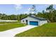 Single Gathering home featuring a modern design, a blue garage door, and a concrete driveway at 17301 Sw 41St Cir, Ocala, FL 34473