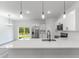 Modern kitchen with stainless appliances, white cabinetry, and a sleek island with stylish pendant lights at 17301 Sw 41St Cir, Ocala, FL 34473