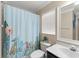 Well-lit bathroom with a toilet, patterned shower curtain, and vanity with mirror at 182 Westmoreland Cir, Kissimmee, FL 34744