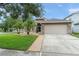 Traditional home boasting a well-manicured lawn, mature trees, and a two-car garage at 182 Westmoreland Cir, Kissimmee, FL 34744