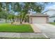 Charming single-Gathering home with a two-car garage, manicured lawn, and welcoming brick pathway at 182 Westmoreland Cir, Kissimmee, FL 34744