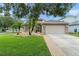 Charming single-story home with a well-manicured lawn, palm trees, and a two-car garage at 182 Westmoreland Cir, Kissimmee, FL 34744