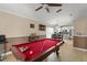 Game room features a red pool table and view into the kitchen with eat-in dining at 182 Westmoreland Cir, Kissimmee, FL 34744