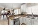 Kitchen area with granite counters and stainless steel dishwasher, overlooking dining and game area at 182 Westmoreland Cir, Kissimmee, FL 34744