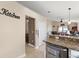 Kitchen entrance featuring granite counters and white cabinets, overlooking dining and game area at 182 Westmoreland Cir, Kissimmee, FL 34744