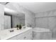 Elegant bathroom featuring marble tiling, dual vanity sinks, jetted tub, and large mirror at 1836 Se 6Th Ave, Ocala, FL 34471