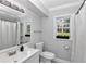 Bright bathroom featuring toilet, modern vanity with sink, and large window at 1836 Se 6Th Ave, Ocala, FL 34471