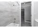 Bright bathroom featuring a bathtub with stylish tile surround and gray tile flooring at 1836 Se 6Th Ave, Ocala, FL 34471