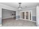 Dining room with gray tile flooring, French doors, pendant lighting, and a view into the kitchen at 1836 Se 6Th Ave, Ocala, FL 34471