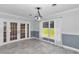 Dining room with gray tile flooring, a large window with sheer curtains, and French doors at 1836 Se 6Th Ave, Ocala, FL 34471