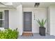 Welcoming entryway with a modern gray door, potted plant, and 'welcome' mat at 1836 Se 6Th Ave, Ocala, FL 34471