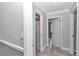 Hallway with gray tile flooring and open doors, offering a glimpse into the bathroom and bedroom at 1836 Se 6Th Ave, Ocala, FL 34471