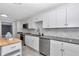 Beautiful kitchen with white cabinets, stainless steel appliances, granite countertops, and gray tile flooring at 1836 Se 6Th Ave, Ocala, FL 34471