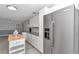 Kitchen featuring white cabinets, granite countertops, a stainless refrigerator, and gray tile flooring at 1836 Se 6Th Ave, Ocala, FL 34471