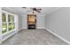 Spacious living room with a decorative stone fireplace, ceiling fan, and neutral tile flooring at 1836 Se 6Th Ave, Ocala, FL 34471