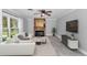 Bright living room with stone fireplace, ceiling fan, tile flooring, and white sofa set at 1836 Se 6Th Ave, Ocala, FL 34471