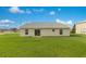 Exterior of home with a green lawn and sliding glass doors to the backyard at 200 Cimarron Dr, Kissimmee, FL 34759