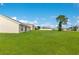 A spacious lawn extends from the rear of the house, offering ample space for outdoor activities at 200 Cimarron Dr, Kissimmee, FL 34759