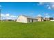 Expansive backyard featuring a well-maintained lawn and the rear of the house with sliding glass doors at 200 Cimarron Dr, Kissimmee, FL 34759