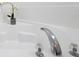 Close up on the bright white soaking tub with chrome hardware and decorative flower at 200 Cimarron Dr, Kissimmee, FL 34759