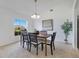 Light-filled dining room features a chandelier, artwork, and backyard view through a large window at 200 Cimarron Dr, Kissimmee, FL 34759