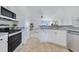 Well-lit kitchen featuring white cabinets, stainless steel appliances, and a view through to the dining room at 200 Cimarron Dr, Kissimmee, FL 34759