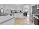 Bright, functional kitchen with stainless steel appliances and white cabinetry, offering a glimpse into the living area at 200 Cimarron Dr, Kissimmee, FL 34759